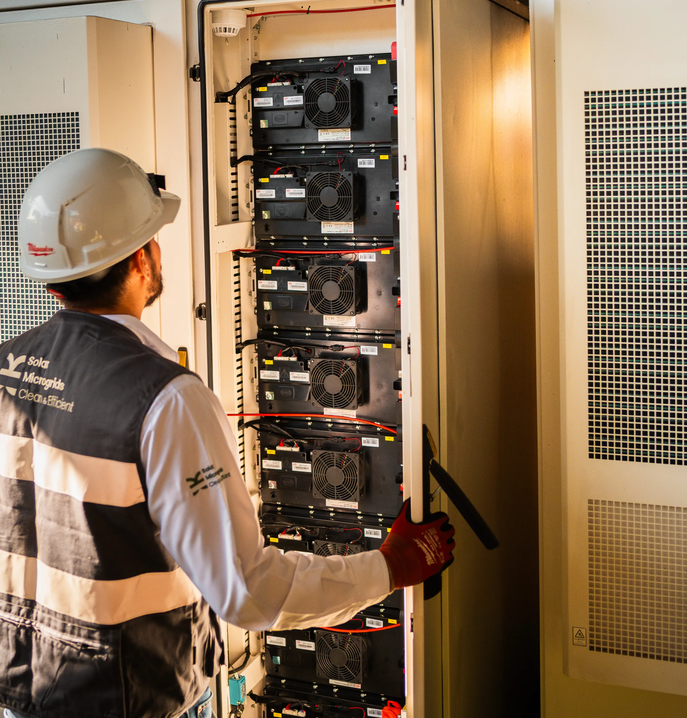 Técnico greenenergy revisando un gabinete de baterías abierto